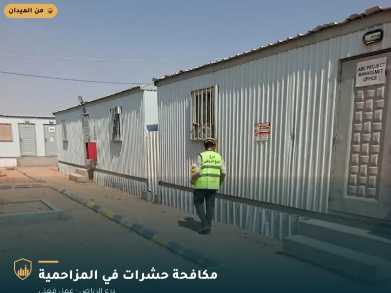 فني درع الرياض يتجول بمعدات الرش في موقع سكن عمالي