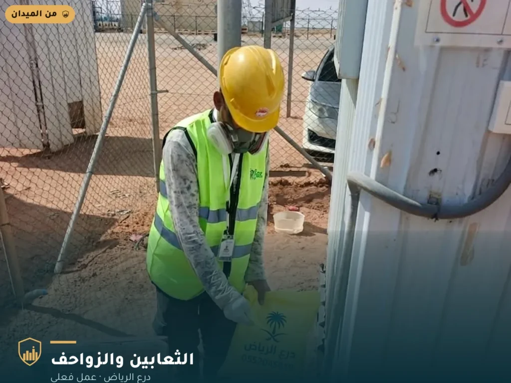 فني درع الرياض يحمل كيس درع الرياض في موقع سكن عمالي